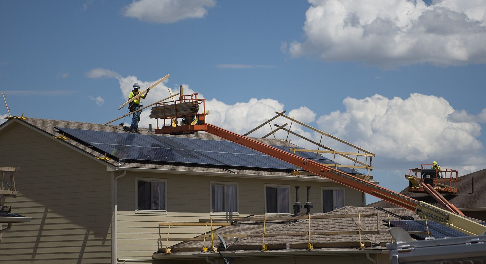 Three Rivers Exteriors crew on a two-story roof in Joliet with a lift bringing up material