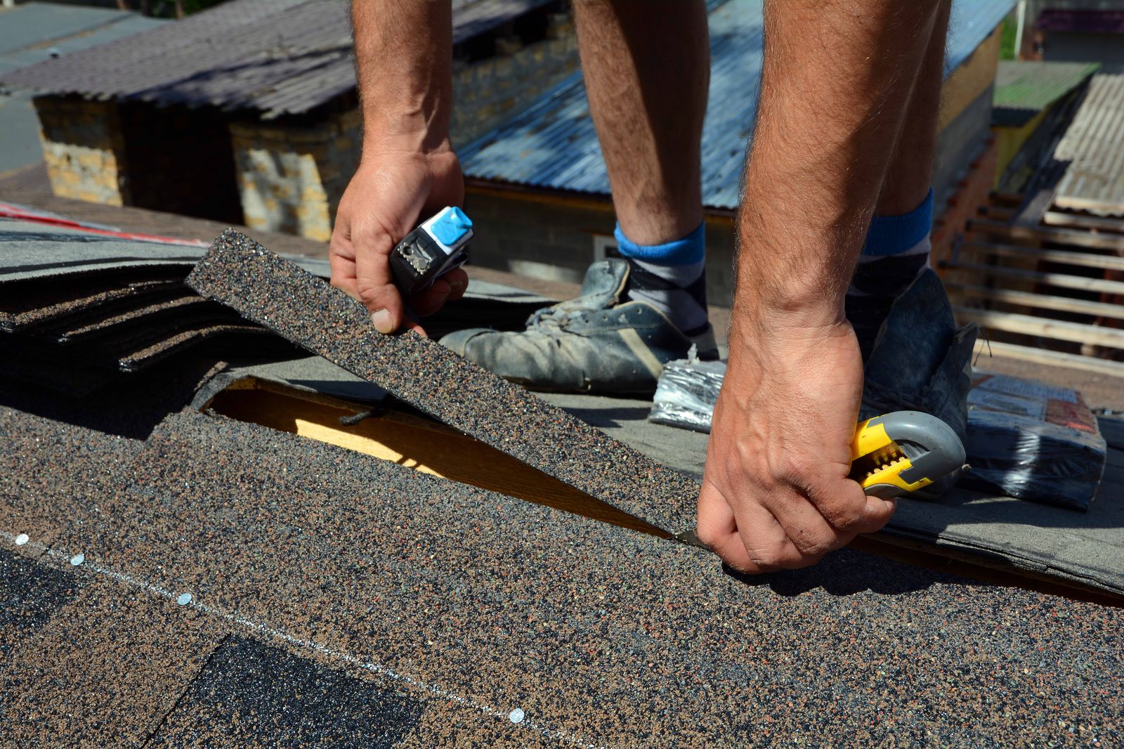Roofer cutting an architectural shingle to fit at the rake edge