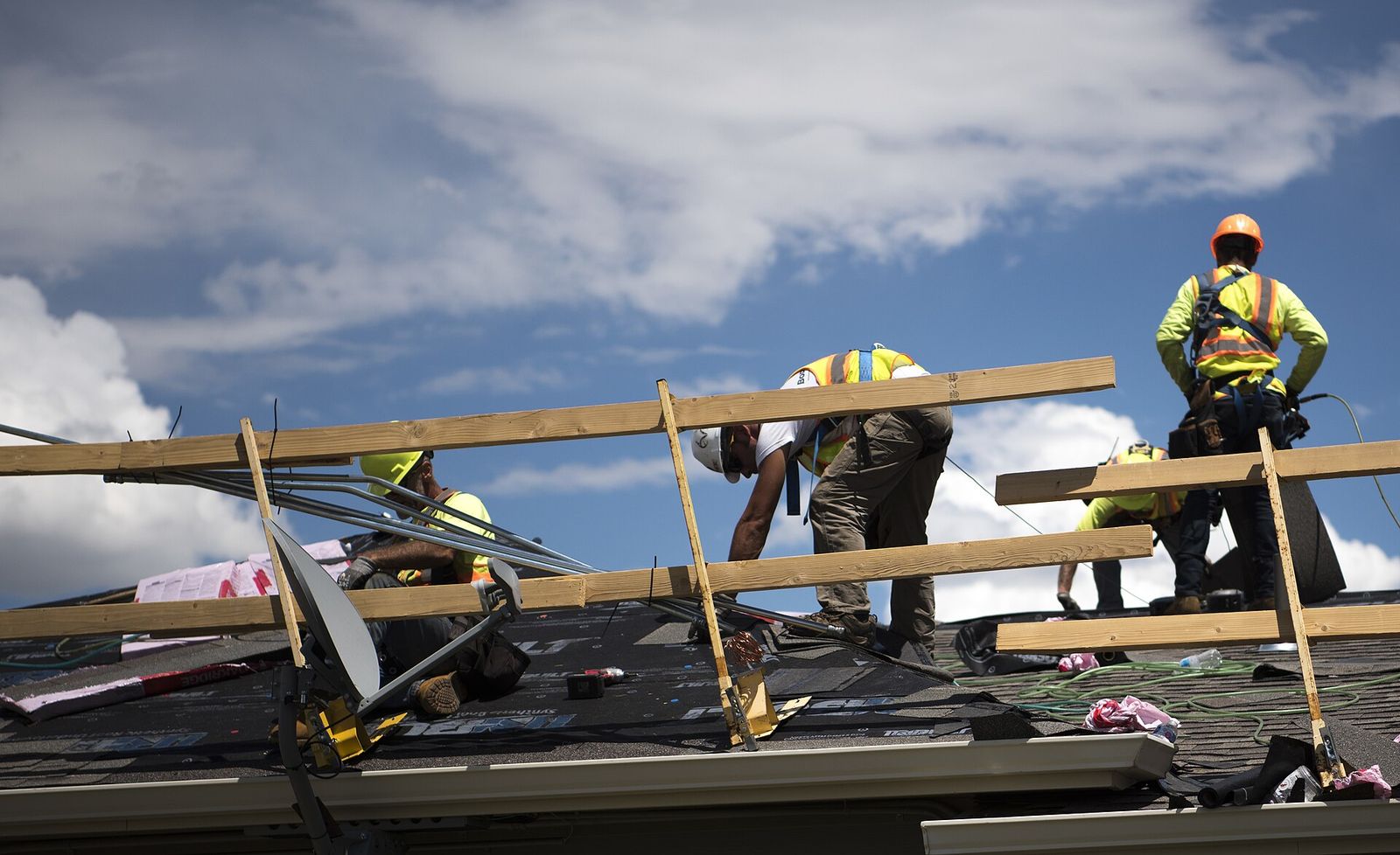 Three Rivers crew laying shingles across a long two-story roof