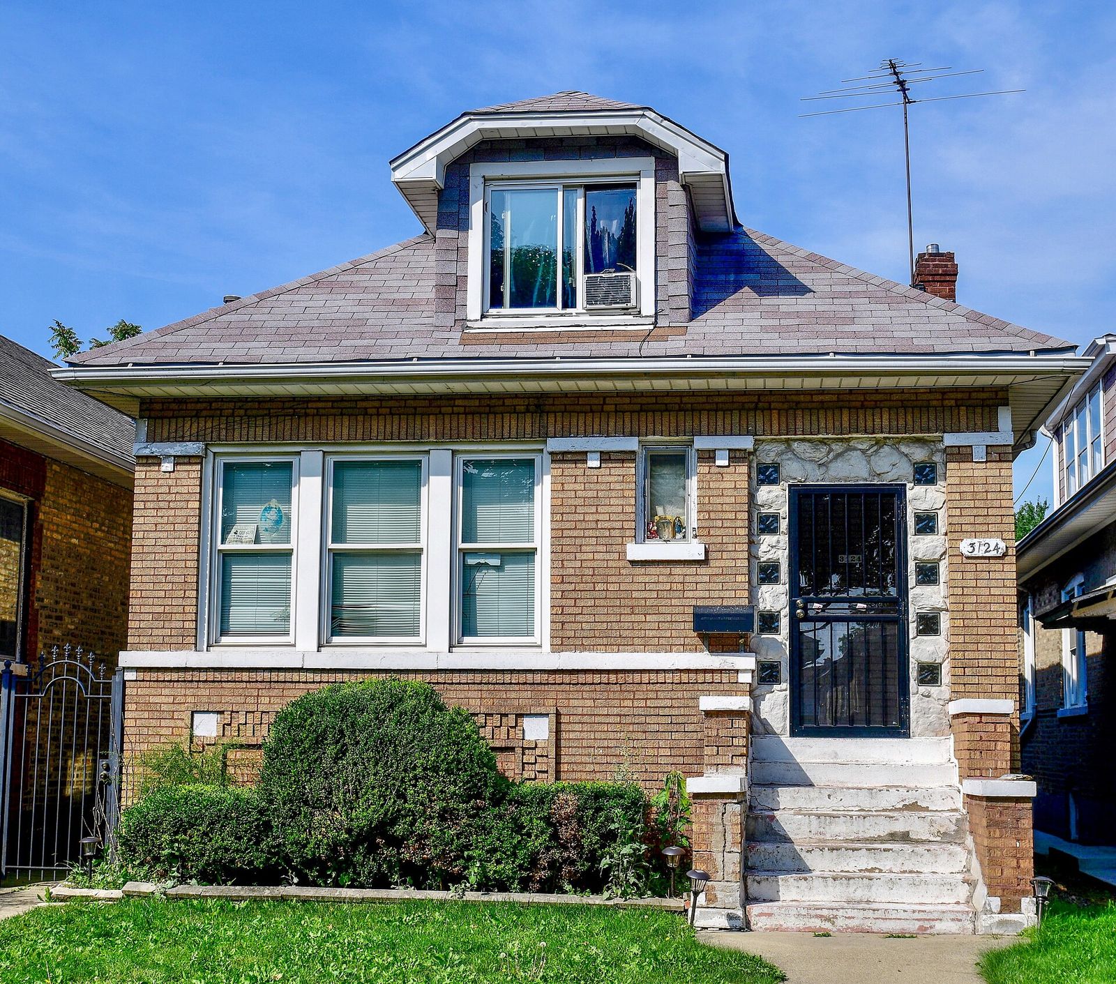 Brick bungalow with a new architectural shingle roof and dormer